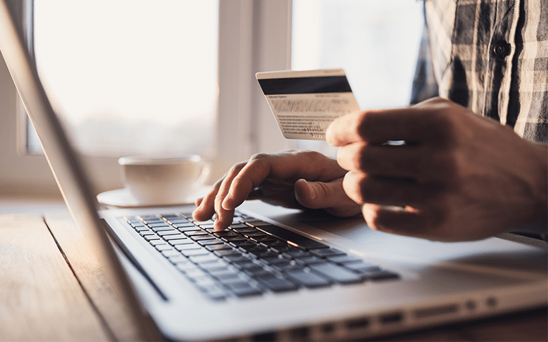Cognitive Search man using his laptop while holding a credit card