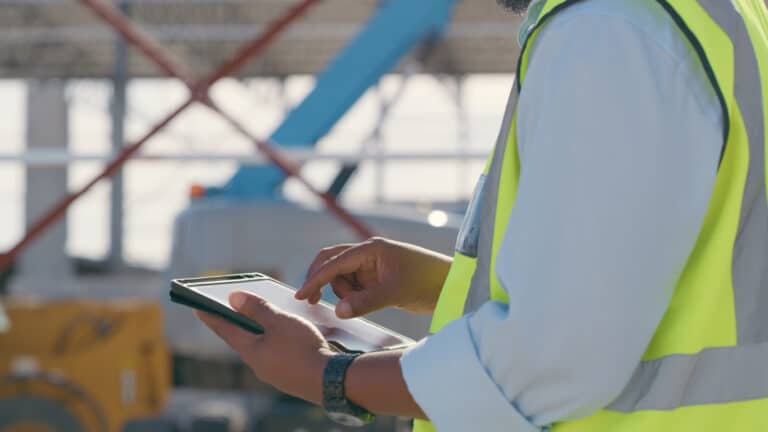 Hands, construction and tablet at site for project management, building logistics or app. Closeup of person and engineering worker on digital technology at industrial architecture design demonstrating B2B site search.