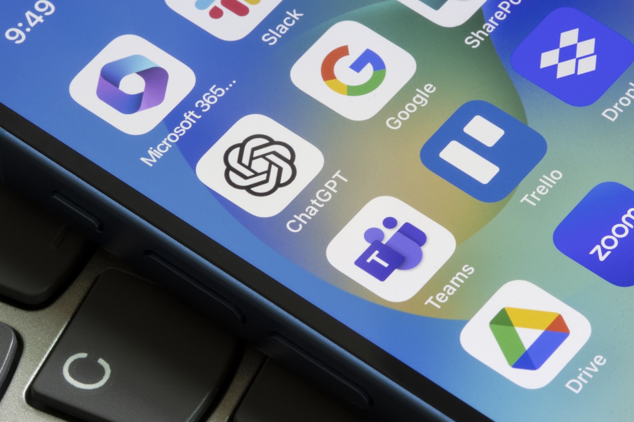 Assorted productivity apps are seen on an iPhone, including ChatGPT, Microsoft 365, Slack, Google, Teams, Trello, Dropbox, Google Drive, and Zoom.