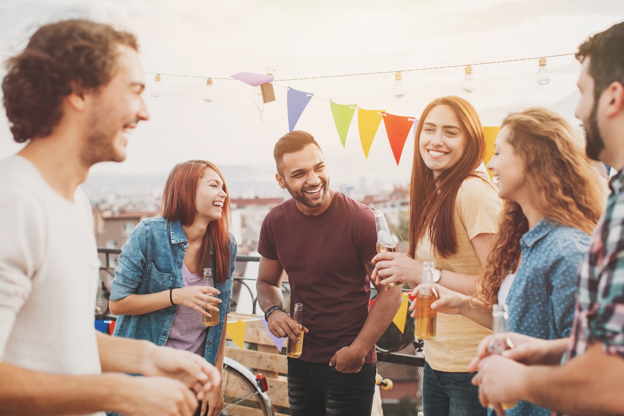Multi-ethnic group of young people chatting and laughing on a rooftop party, representing how semantic vector search connects concepts together similar to how some friends at a party with similar characteristics will be grouped together. 