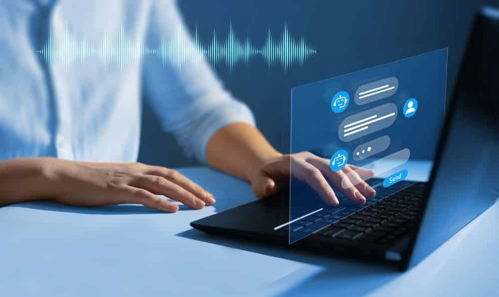 Hands on black laptop on blue table with a blue background