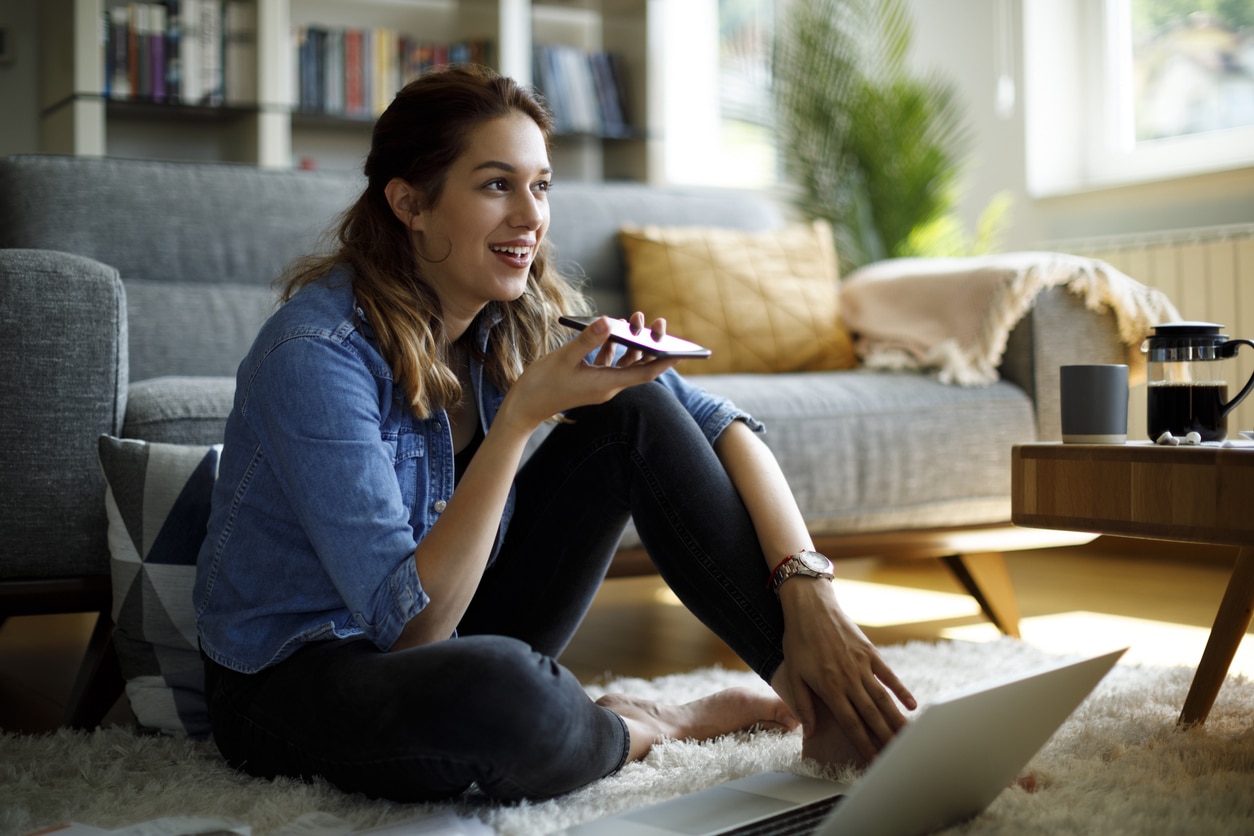 Young woman using mobile phone for working at home; illustrating how AI search and AI-powered recommendations are mainstream