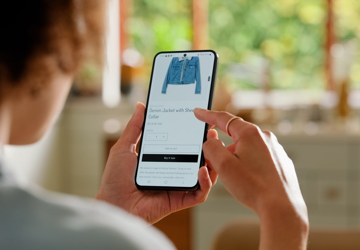 Online shopping, home and person with phone, clothes and e commerce, digital and browsing for sale. Choice, decision and fashion for customer, back view and app in mobile, technology and internet representing personalization in ecommerce