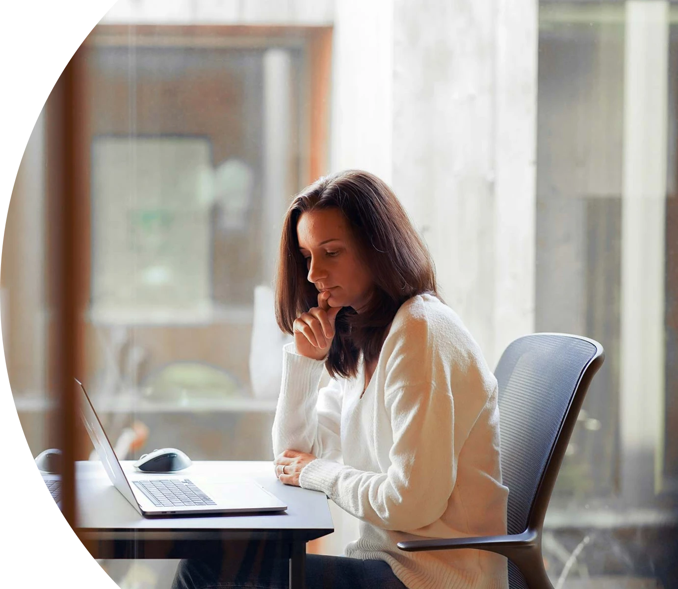 Woman working at a laptop desk.