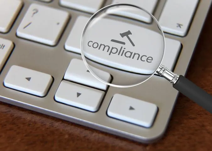 Magnifying glass over compliance key